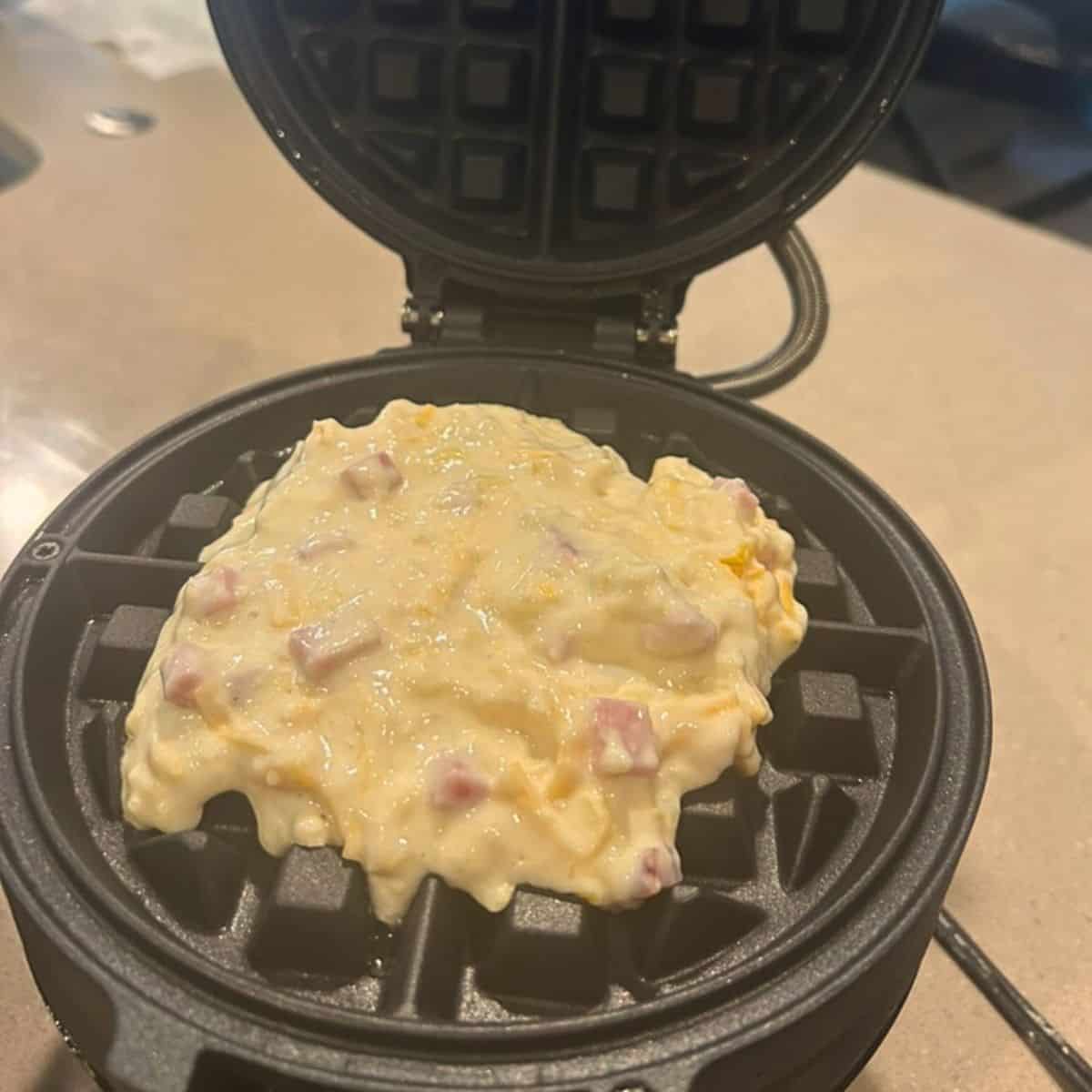 Ham and cheese waffle batter on waffle iron